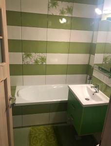 een groene en witte badkamer met een bad en een wastafel bij Apartament Central in Ploieşti