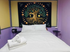 a bedroom with a bed with a tree on the wall at Serenity House 4D in Ban Ko Khwan