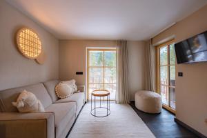 un salon avec un canapé et une table dans l'établissement Hugo und Pepi Appartements, à Mittelberg