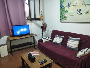 een woonkamer met een bank en een tv bij Palermo Candombe House in Montevideo