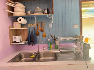 a kitchen sink with a dish drying rack above it at Serenity House 4D in Ban Ko Khwan