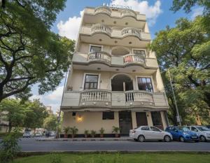 een hoog gebouw met auto's ervoor geparkeerd bij FlexiBay-Affordable Hostel in North Delhi in Delhi