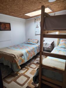 a bedroom with two bunk beds and a ceiling at La Casa de Sandrita in Castro