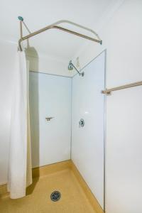 La salle de bains est pourvue d'une douche avec une porte en verre. dans l'établissement ibis Budget Brisbane Airport, à Brisbane