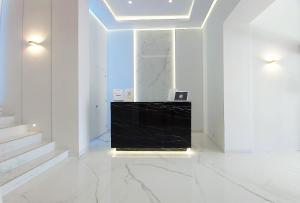 a white room with a staircase and a black wall at Akrogiali Exclusive Hotel (Adults Only) in Polychrono