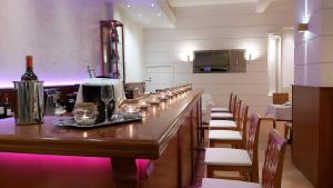 a bar in a restaurant with a row of wine glasses at Akrogiali Exclusive Hotel (Adults Only) in Polychrono