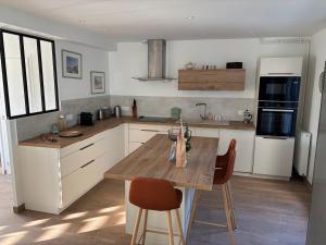 une cuisine avec une table et des chaises en bois dans l'établissement Maison bord de mer normandie, à Langrune-sur-Mer
