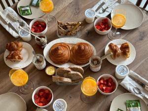 een houten tafel met ontbijtproducten en drankjes erop bij MAISON LOU PIADE Sarlat Your Luxury Farm Hôtel & Confidential place to stay in Sarlat in Sarlat-la-Canéda