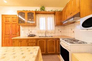 een keuken met houten kasten en een witte kookplaat oven bij Kalemi House in Kato Korakiana