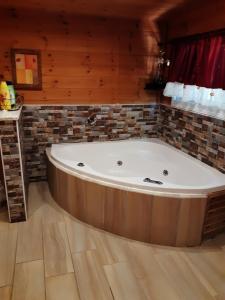 a large bath tub in a room with wooden walls at בקתת העץ של מירה ואמיר in Beit Hillel