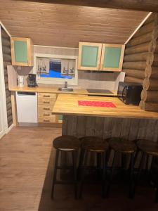 a kitchen with a counter and stools in a room at Øse Camping in Gratangen