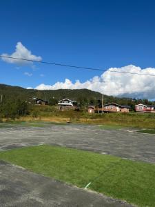 an empty parking lot with houses in the background at Øse Camping in Gratangen +8 photos