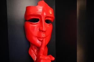 a red sculpture of a face on a wall at Les clés du désir in Épône