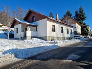 a house on the side of a snow covered street at Prázdninový dům u Špičáku in Albrechtice v Jizerských horách