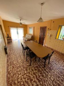 een woonkamer met een houten tafel en stoelen bij Villa Messina, Casa di Vacanza in Juana Koslay 