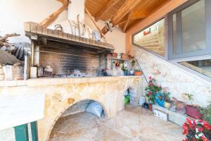 een keuken met een stenen open haard in een huis bij Kalemi House in Kato Korakiana