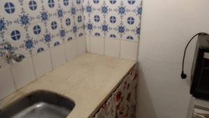 een kleine keuken met een wastafel en blauwe en witte tegels bij Palermo Candombe House in Montevideo +66 foto's