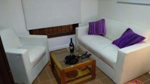 een woonkamer met twee witte stoelen en een tafel bij Palermo Candombe House in Montevideo