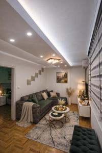 een woonkamer met een bank en een tafel bij Apartman Daluxst in Vrnjačka Banja