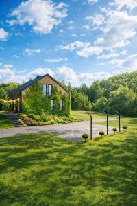 a house covered in ivy on the side of a road at Rezydencja Bieszczady - Solina in Solina