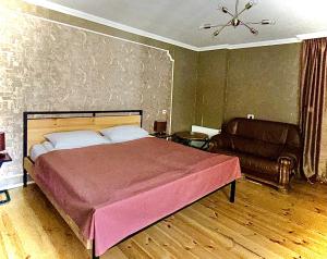 een slaapkamer met een groot bed en een bank bij Apartment Once in Kazbegi in Kazbegi