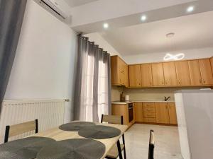 a dining room with a table and a kitchen at VASKO Luxury Suites 3 in Siátista