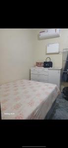a bedroom with a large bed and a dresser at Casa com 3 quarto mobiliada in Manaus