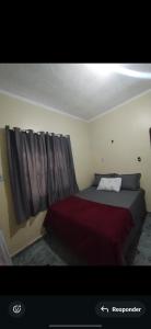 a bedroom with a bed with a red blanket at Casa com 3 quarto mobiliada in Manaus