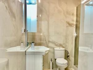 a white bathroom with a toilet and a sink at VASKO Luxury Suites 3 in Siátista