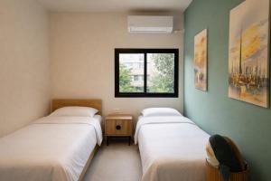 a room with two beds and a window at Luxury point in Giv‘atayim
