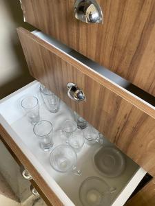 een lade met glazen in een wastafel in de badkamer bij Chalé da lagoa in Paraibuna +33 foto's