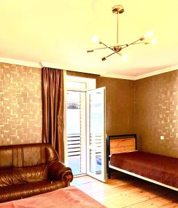 een woonkamer met een bank en een plafondventilator bij Apartment Once in Kazbegi in Kazbegi +8 foto's