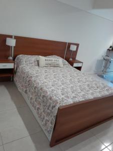 a bed with a wooden headboard and a pillow on it at Vane Bravo in Mar del Plata