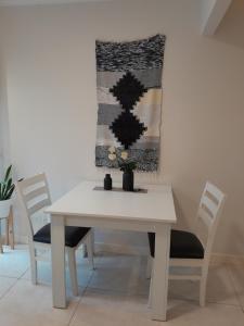 a white table and chairs with a rug on the wall at Vane Bravo in Mar del Plata