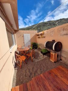 un patio con un tavolo e una cisterna d'acqua di Viejo Lobo de Mar a Puerto Pirámides Altre 5 foto
