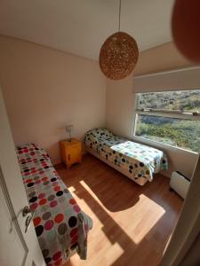 una camera da letto con due letti e una finestra di Viejo Lobo de Mar a Puerto Pirámides