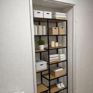 een boekenplank met handdoeken en dozen in een kamer bij Maisonette am Burg in Möckmühl