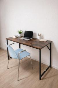 een houten bureau met een laptop en een stoel bij Maisonette am Burg in Möckmühl