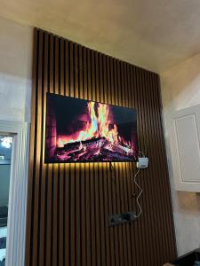 a tv hanging on a wall with a fire in it at Sultan Villas A-Frame in Quba in Quba