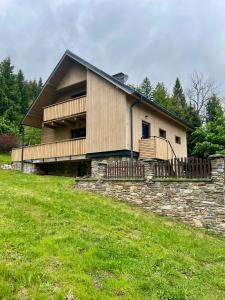 a house on a hill with a stone wall at Chalupa Bohunka in Kašperské Hory