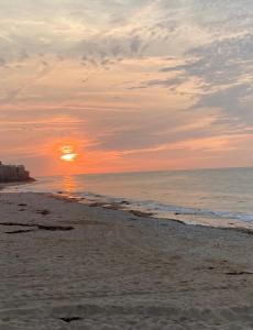 - un coucher de soleil sur une plage donnant sur l'océan dans l'établissement Maison bord de mer normandie, à Langrune-sur-Mer 5 autres photos