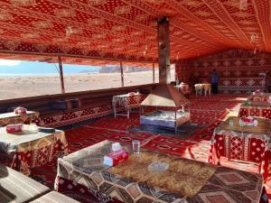 una grande sala con tavoli in una sala sulla spiaggia di wadi Rum Desert Legends a Wadi Rum