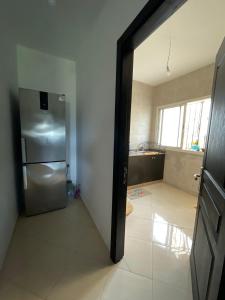 a kitchen with a stainless steel refrigerator in a room at Appartement à Skhirat plage in Skhirat