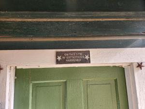 un panneau au-dessus d'une porte verte avec un panneau au-dessus dans l'établissement Bigfoots Bungalow, à Bandera