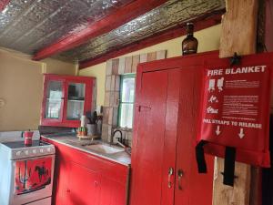 une cuisine rouge avec un évier et un placard rouge dans l'établissement Bigfoots Bungalow, à Bandera 14 autres photos