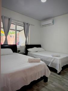 una camera da letto con due letti e una finestra di Tu hogar en Tauramena a Tauramena Altre 12 foto
