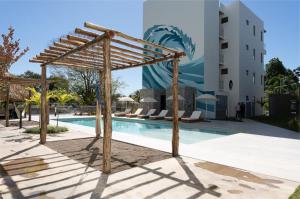 a wooden pergola next to a swimming pool at Spacious 2BR 2BTH El Zonte with oceanview and pool in El Zonte