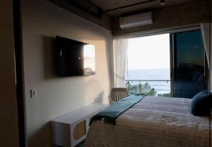 a bedroom with a bed with a television and a window at Spacious 2BR 2BTH El Zonte with oceanview and pool in El Zonte +44 photos
