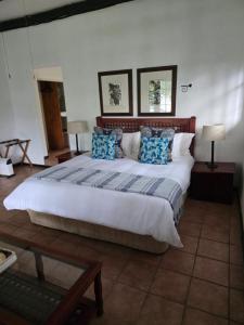 ein Schlafzimmer mit einem großen Bett und blauen Kissen in der Unterkunft Kruger Island Resort in White River