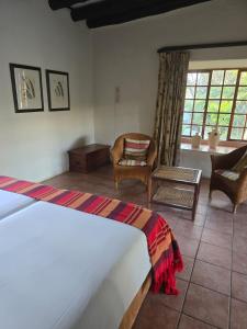 ein Schlafzimmer mit Bett und ein Wohnzimmer in der Unterkunft Kruger Island Resort in White River + 64 Fotos